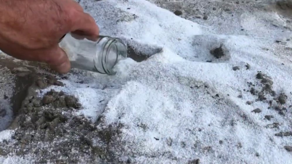 Volunteers are collecting fine plastic dust in a container.